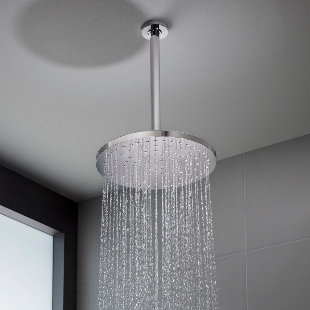 Lifestyle image of the Roca RainSense Chrome 250mm Round Shower Head installed in the ceiling with water flowing